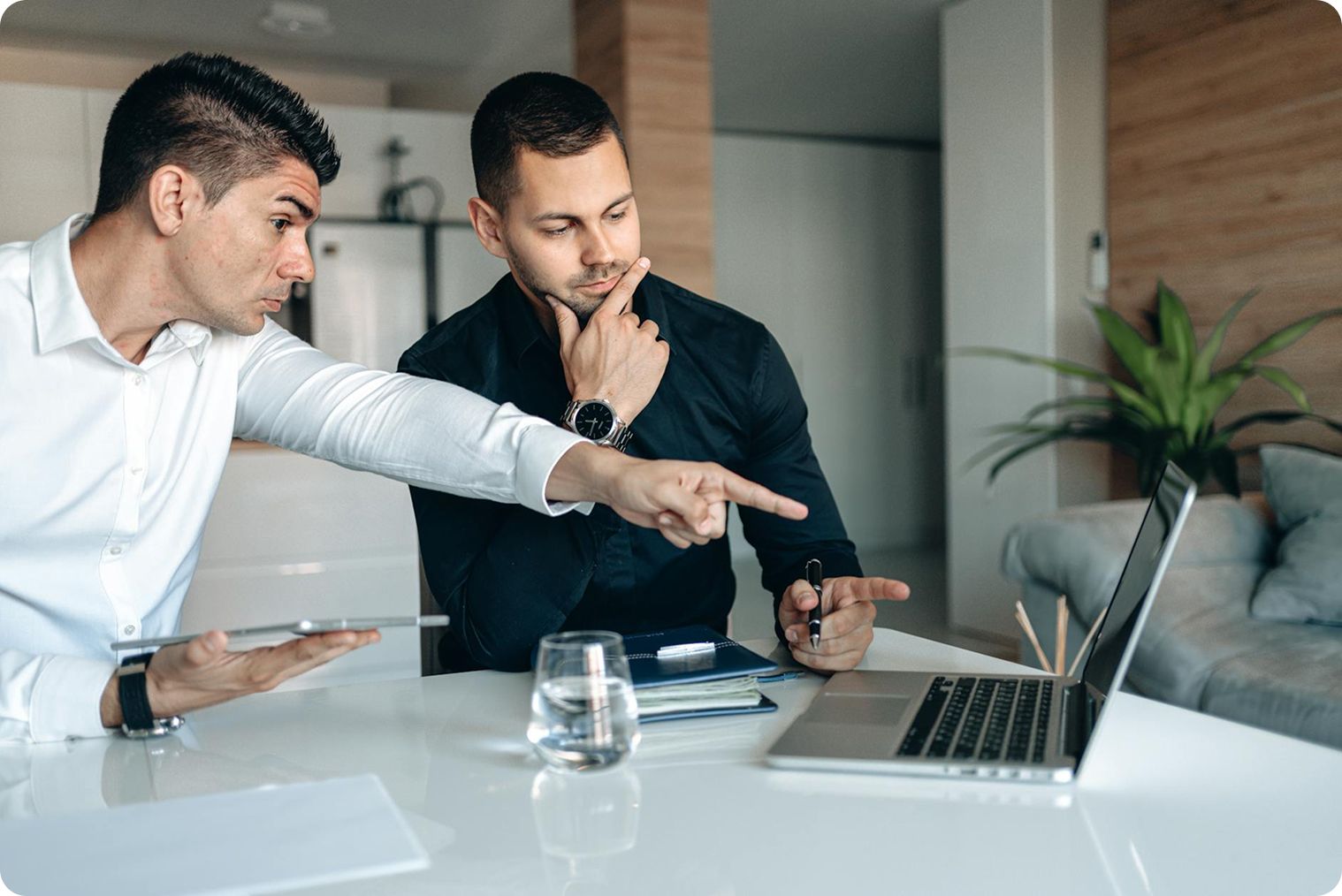 Deux hommes qui parlent et pointent un ordinateur