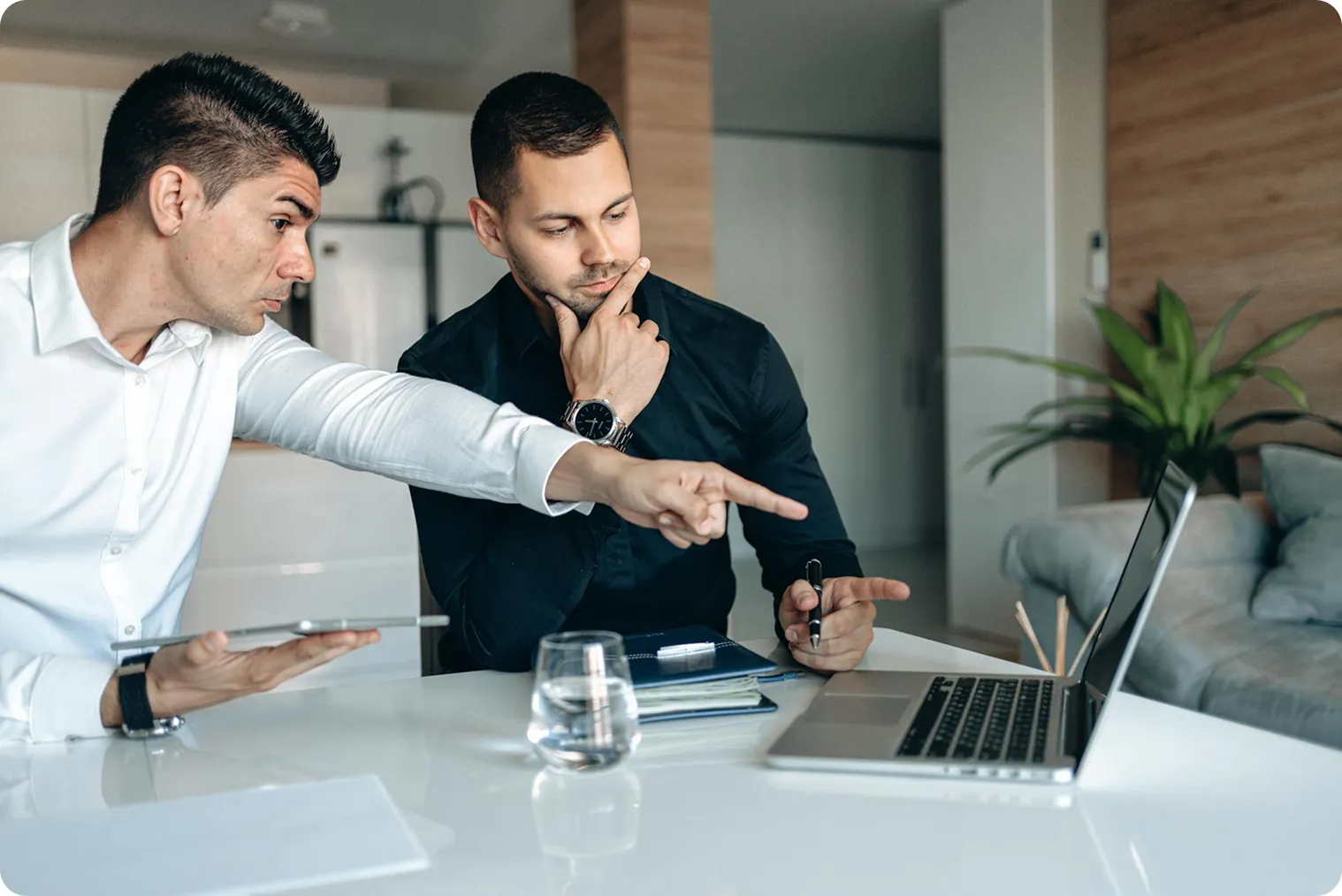 Deux hommes qui parlent et pointent un ordinateur